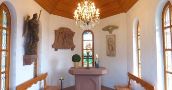 Andachten auf dem Michelsberg Der Altarraum der Michelskapelle in Bad Dürkheim mit Altar, Wandreliefs und einer großen Statue des Erzengels Michael