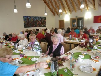 Frauen Frauen unterschiedlichen Alters sitzen bei einem ökumenischen Frauentreffen an einem festlich gedeckten Tisch